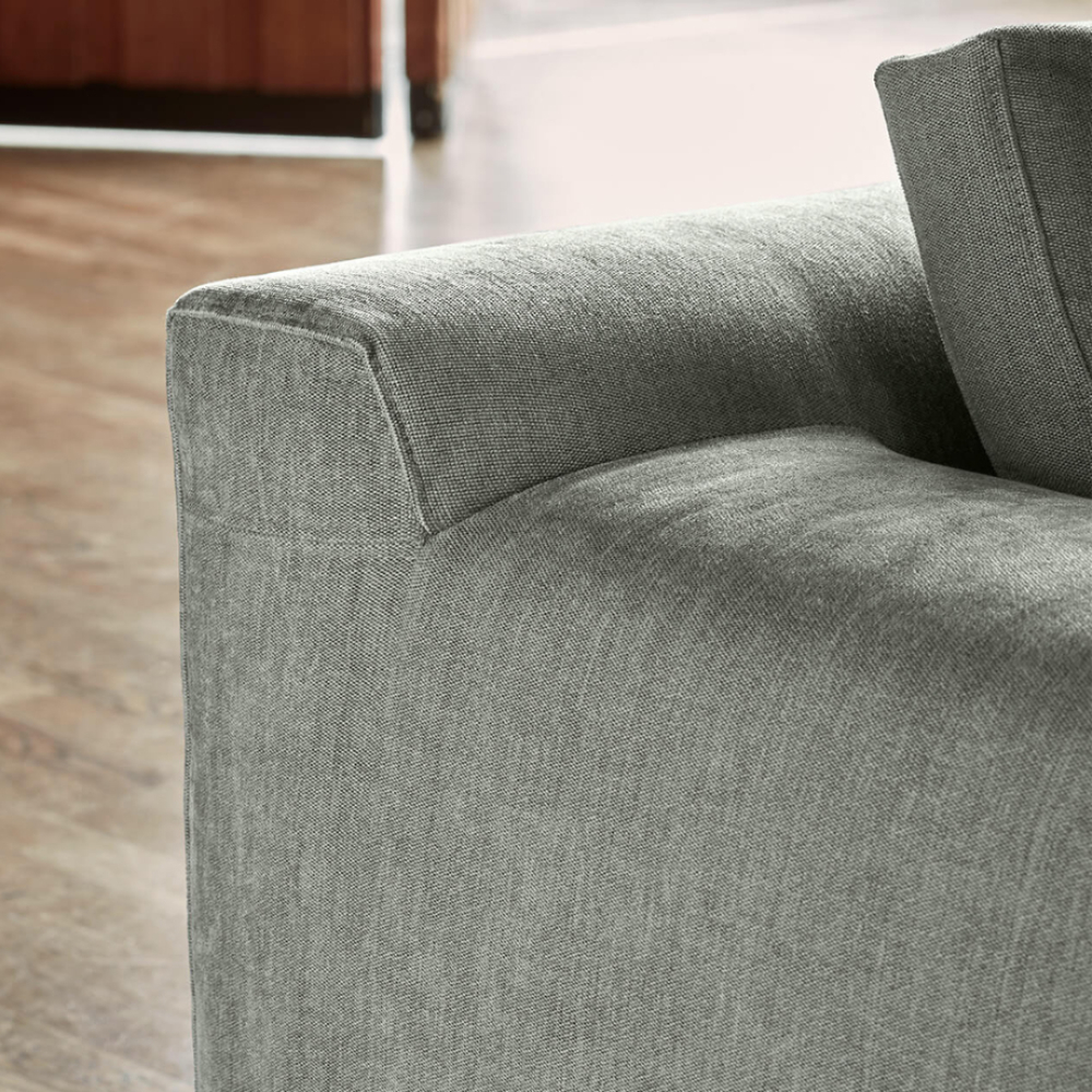 Close-up of the Eilersen Aton Sofa showing the armrest and seat in soft grey upholstery.