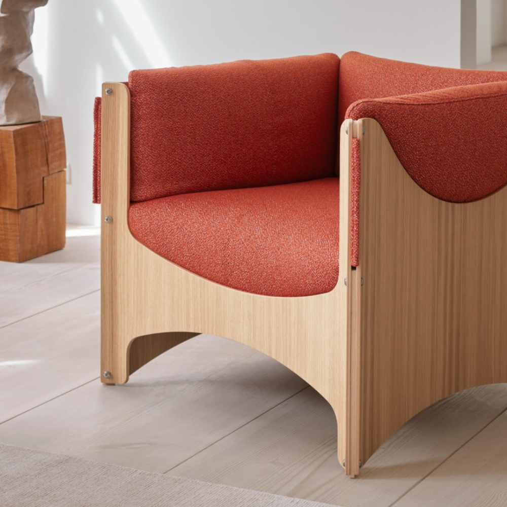 Close-up of the Eilersen Bug Chair with an oak frame and textured red upholstery.