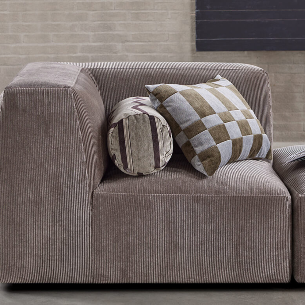 Detail of the Eilersen Ares Sofa in brown corduroy, styled with patterned throw cushions.