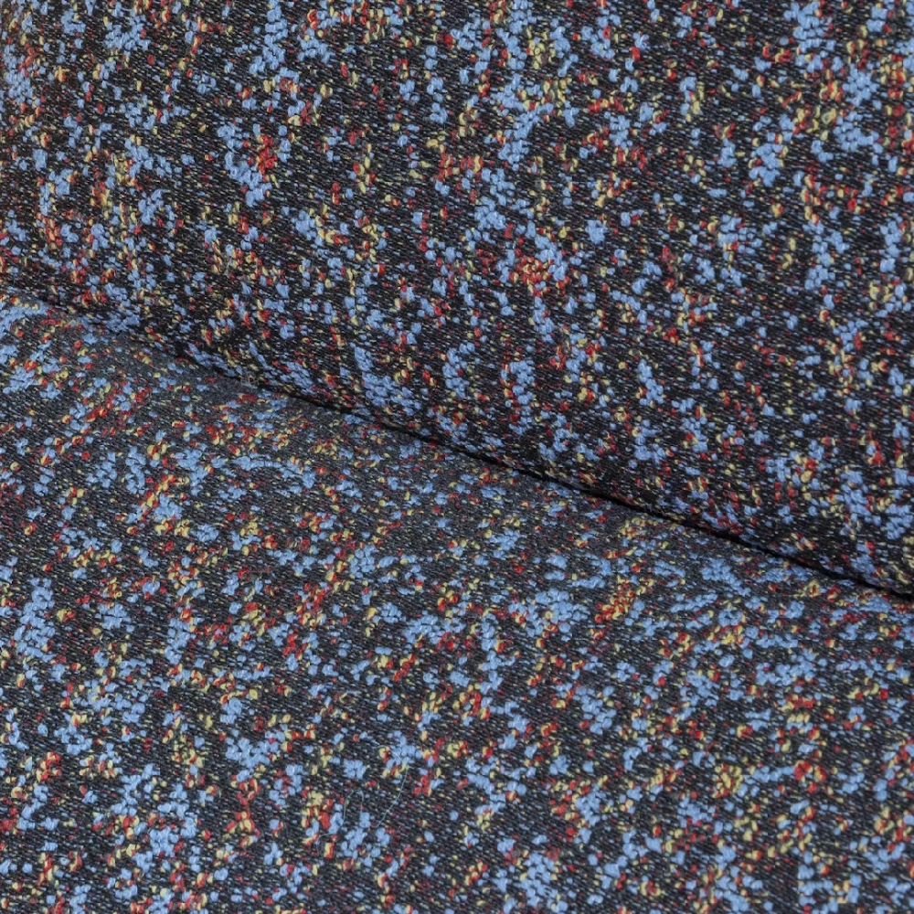 Close-up of Kvadrat Atom upholstery fabric with dense multicolour woven texture in blue, red and neutral tones