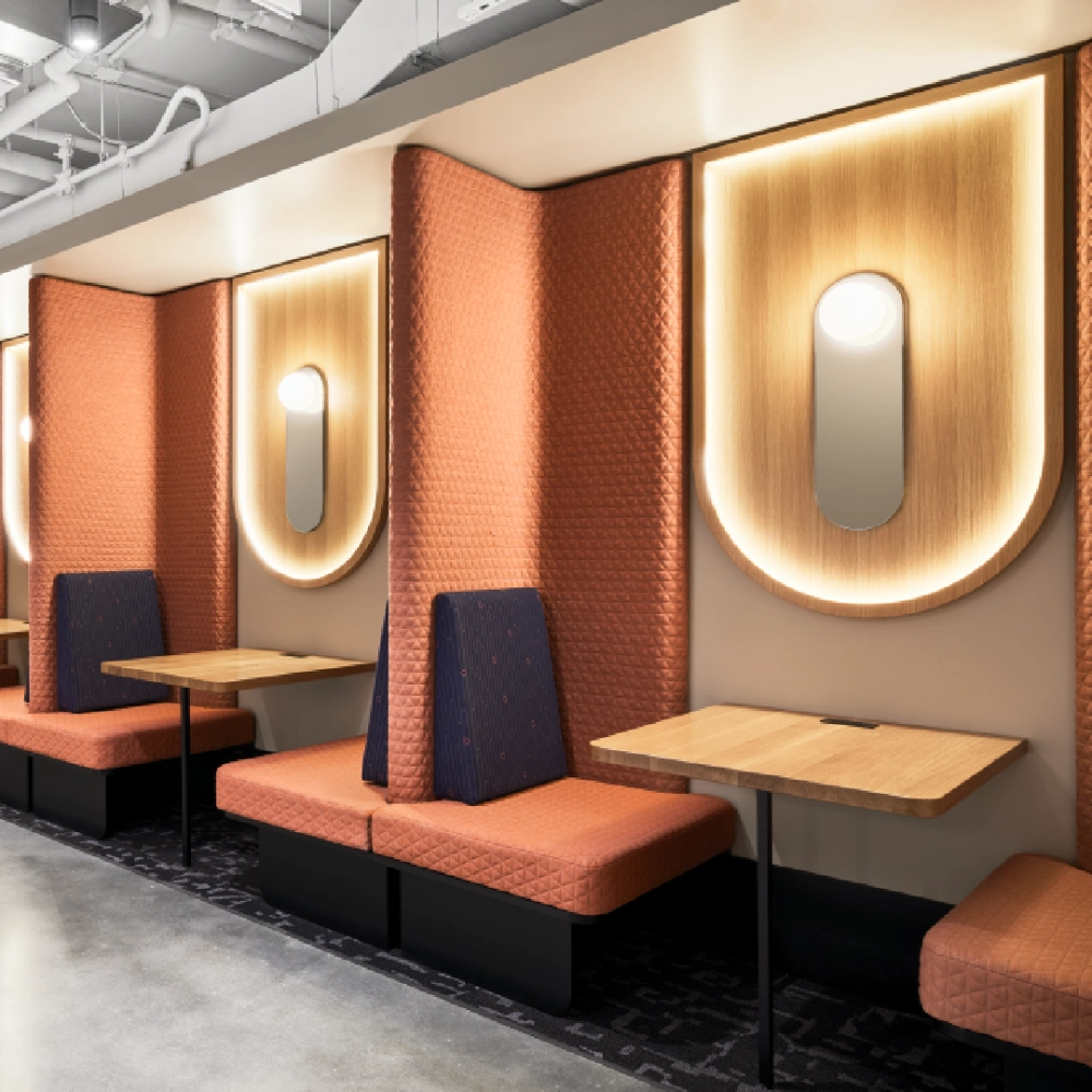 Commercial booth seating upholstered in Kvadrat fabric, modern hospitality interior with textured acoustic panels