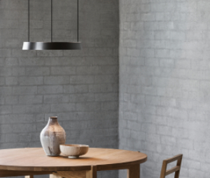 Light-Point Copenhagen EDGE Orbit pendant and matching EDGE floor lamp, delivering precise, directional lighting in a modern dining and living area with exposed brick walls.