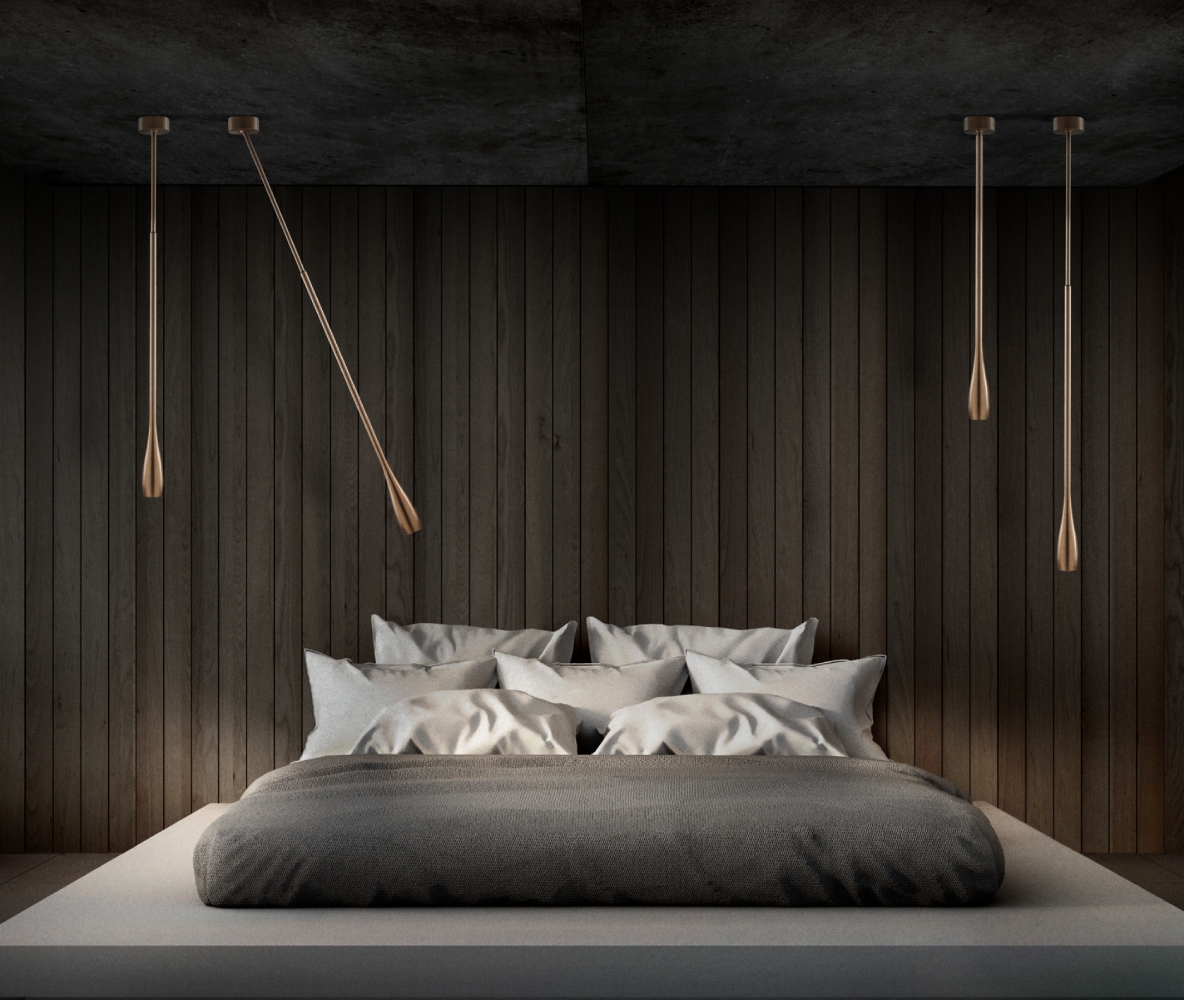Light-Point Copenhagen TULIP pendant lights in rose gold, suspended beside a modern bed to create soft, focused bedroom lighting against dark timber walls.